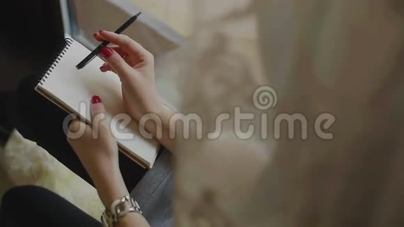 女性用记事本和铅笔思考视频的预览图