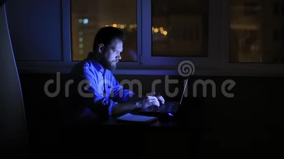 一个疲惫的商人晚上工作到很晚办公室里拿着一台笔记本电脑写了一份财务报告视频的预览图
