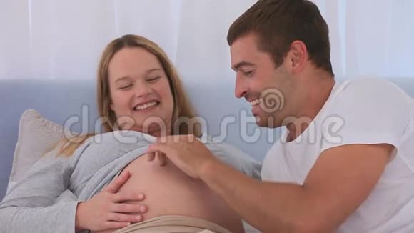 男人玩弄他的妻子的肚子视频的预览图