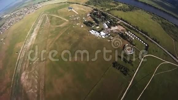 专业跳伞运动员飞行在绿色的田野上平衡极端视频的预览图