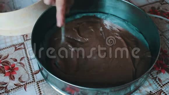 女人把巧克力面团放进烤盘里视频的预览图