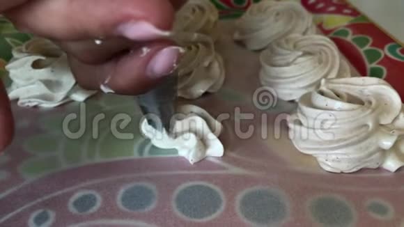 一个女人准备一个白色棉花糖借助糕点包视频的预览图
