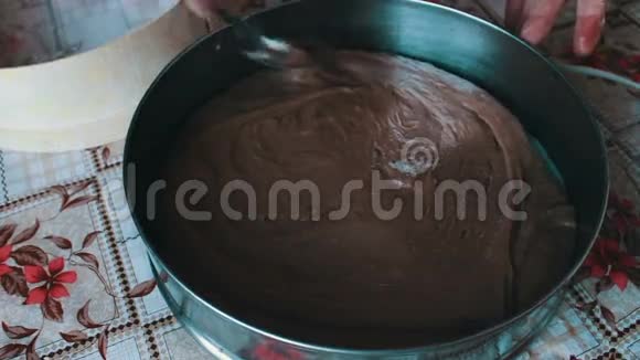 女人把巧克力面团放进烤盘里视频的预览图
