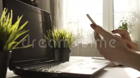 年轻的女设计师正在测试智能手机和电脑上的用户界面那个女人看电话女人坐着视频的预览图