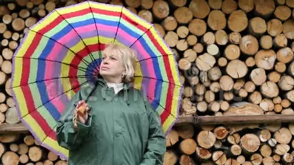 穿绿色光滑衣服的女人站在木材旁边视频的预览图