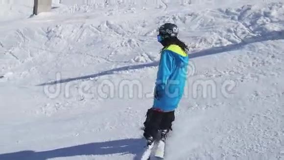 滑雪者在斜坡上滑行跳上栏杆晴朗无云的一天滑雪胜地山脉视频的预览图