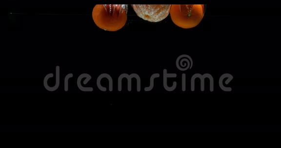 克莱门汀柑橘黑背景下落入水中的水果视频的预览图