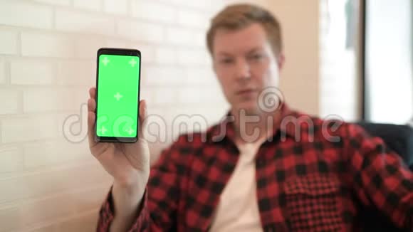 年轻快乐的时髦男人带着电话竖起大拇指视频的预览图