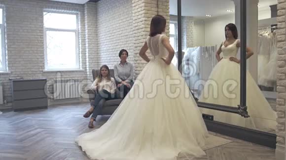 参加婚礼时装店婚纱礼服试衣的女性视频的预览图