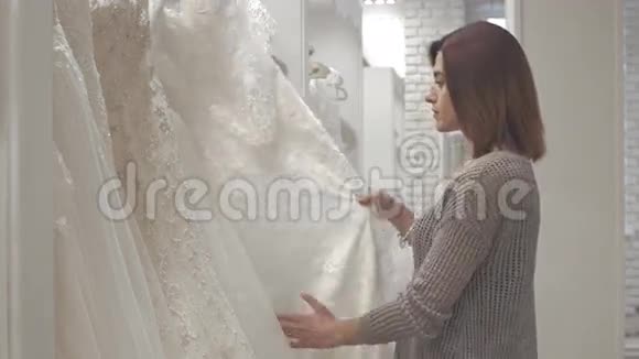 参加婚礼时装店婚纱礼服试衣的女性视频的预览图