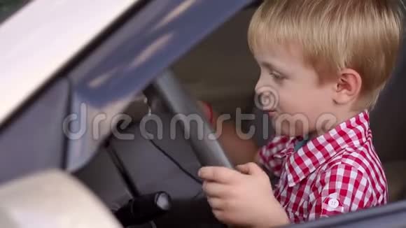 汽车车轮后面一个快乐男孩的肖像视频的预览图