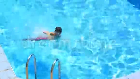 这个孩子正在游泳池的碧水里游泳从上面看视频的预览图