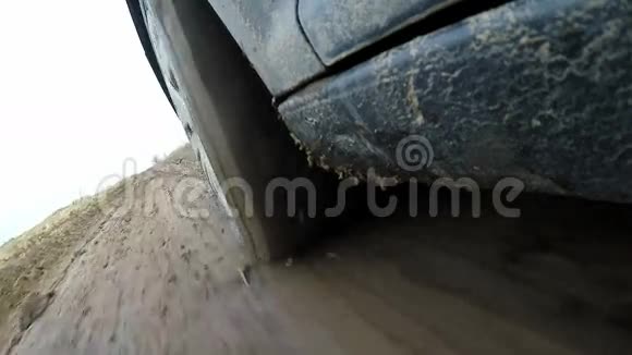 车的车轮在泥泞的森林里越野在乡村公路上开车从外面的小木屋里看慢动作视频的预览图