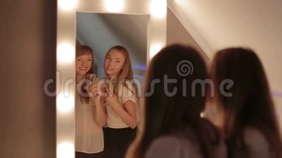 两个女孩在镜子里一起微笑跳舞视频的预览图