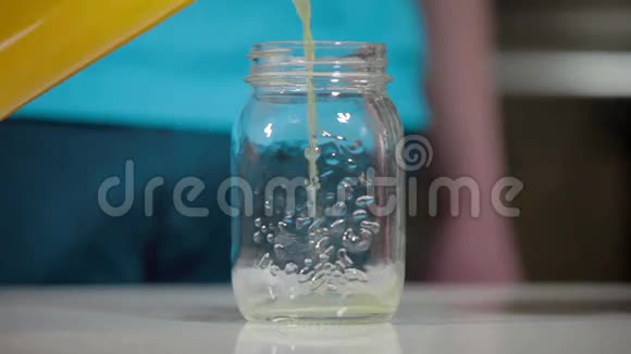 把橙汁从瓶子倒入玻璃瓶视频的预览图
