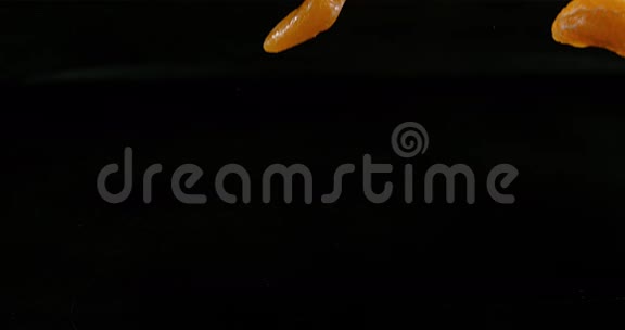 克莱门汀柑橘黑背景下落在水上的水果视频的预览图