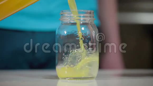 把橙汁从瓶子倒入玻璃瓶视频的预览图