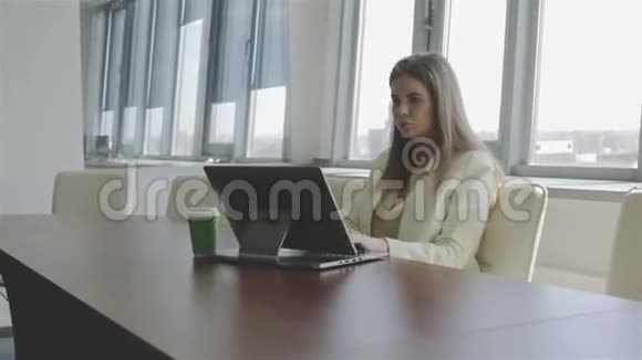 年轻的商务女性正在办公室的办公桌前用笔记本电脑工作视频的预览图