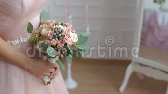 新娘穿着尘土飞扬的粉红色连衣裙手拿花束视频的预览图