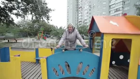一位在操场上玩滑板的老妇人视频的预览图