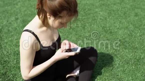 草坪上有智能手机的女人视频的预览图