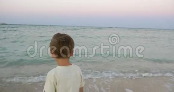 小孩站在海边看着它视频的预览图