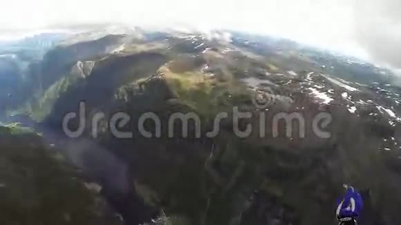 跳伞员打开降落伞在被绿色植物覆盖的山上极限运动视频的预览图