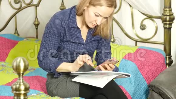 学生躺在家里的床上在笔记本电脑上工作的女人网上教育视频的预览图