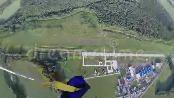 跳伞女孩跳伞在绿色的田野森林上空极限运动太阳视频的预览图