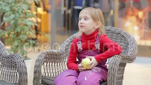 女孩坐在树枝做成的椅子上手里拿着一个苹果视频的预览图