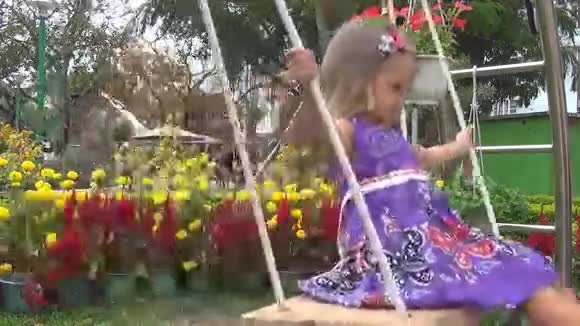 小女孩骑着绳子在花园里荡秋千视频的预览图