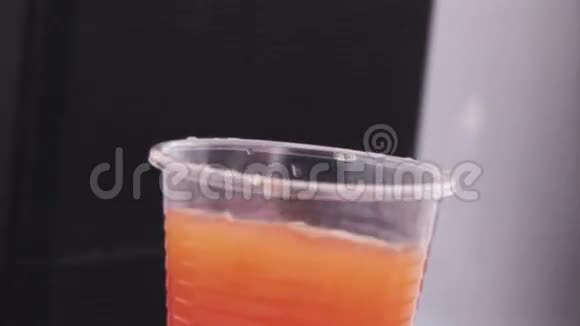 在露天派对上带有橙色饮料的玻璃杯从音乐中摇动假期太阳视频的预览图