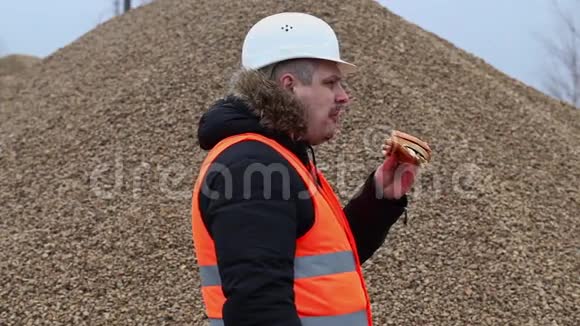 工人在碎石堆里吃汉堡包视频的预览图
