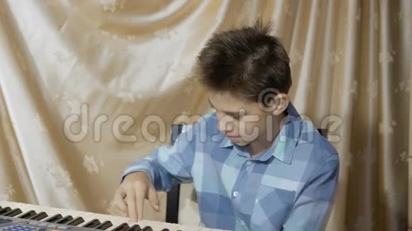 快乐少年在电子钢琴上演奏视频的预览图
