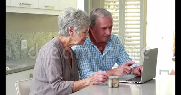 年长夫妇用手提电脑拿药丸视频的预览图