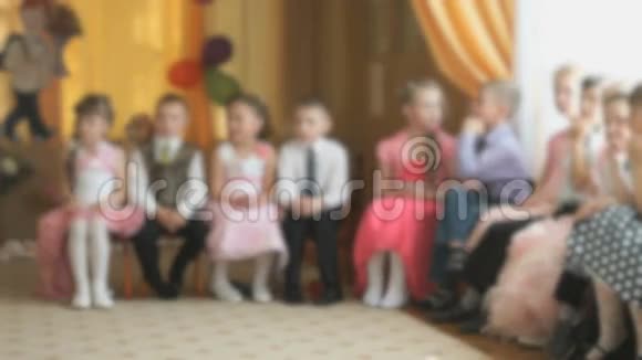 孩子们坐在椅子上看着大厅视频的预览图