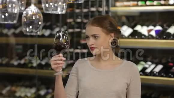 美丽的年轻女子品尝红酒视频的预览图