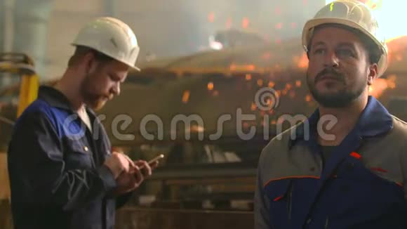 重工业工厂两名严肃工程师工作的肖像火花及焊接背景视频的预览图