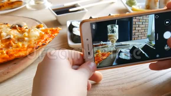 少年男孩在智能手机上拍一张食物的照片餐厅桌上的意大利披萨视频的预览图