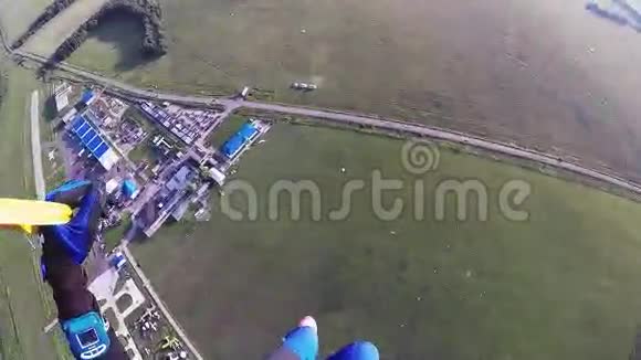 专业跳伞运动员在空中跳伞在绿色的田野道路上身高视频的预览图