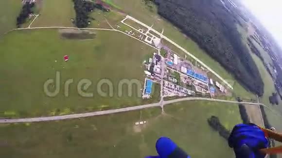 专业的跳伞员在空中跳伞在绿色的田野树林上身高视频的预览图