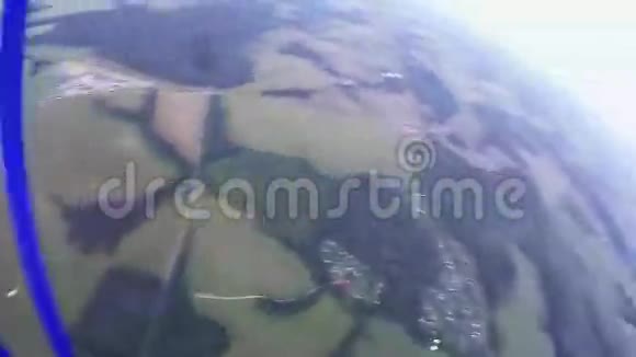 专业跳伞员乘降落伞飞越绿地森林景观视频的预览图