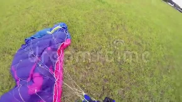 专业跳伞员在降落后在绿野上系降落伞极限运动视频的预览图