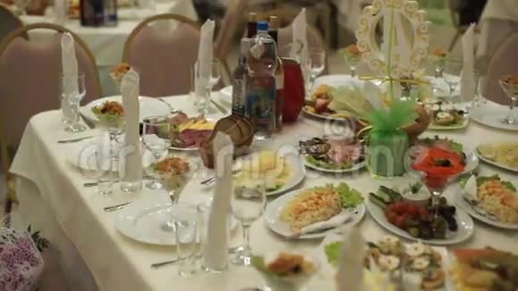 有食物和饮料的桌子宴会前在餐厅提供带银器和玻璃干器的成套服务视频的预览图