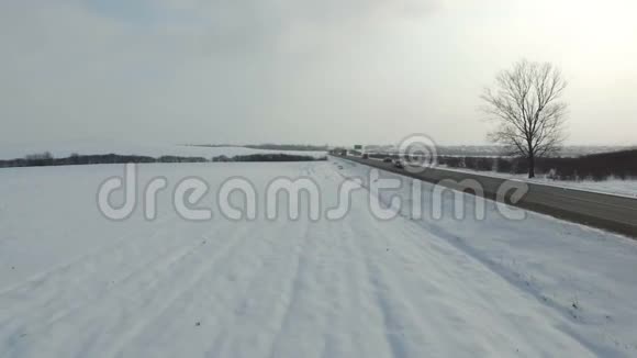 在雪域驾驶冬季道路的卡车的空中射击视频的预览图