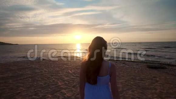 日落时徒步旅行者的女性脚赤脚在岸上行走年轻女子在海滩上的腿视频的预览图