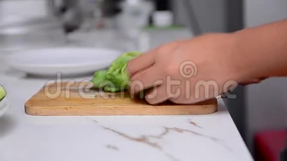 特写和娃娃滑块拍摄妇女手切绿色蔬菜在白色桌子HD1920x1080视频的预览图