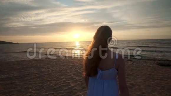 日落时徒步旅行者的女性脚赤脚在岸上行走年轻女子在海滩上的腿视频的预览图