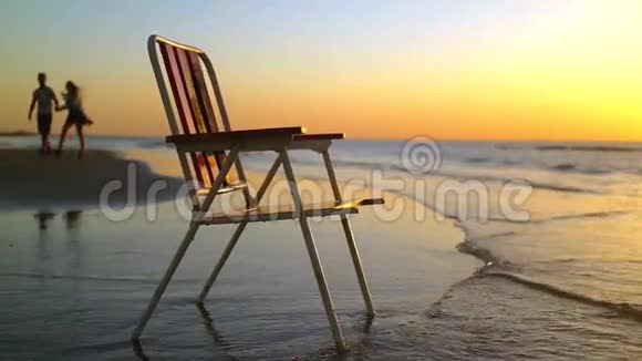 夕阳西下的海岸上的椅子人的背影视频的预览图