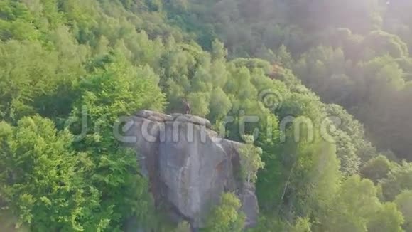 帅哥健美训练在岩石山背景上的绿色森林景观呼吸时刻视频的预览图